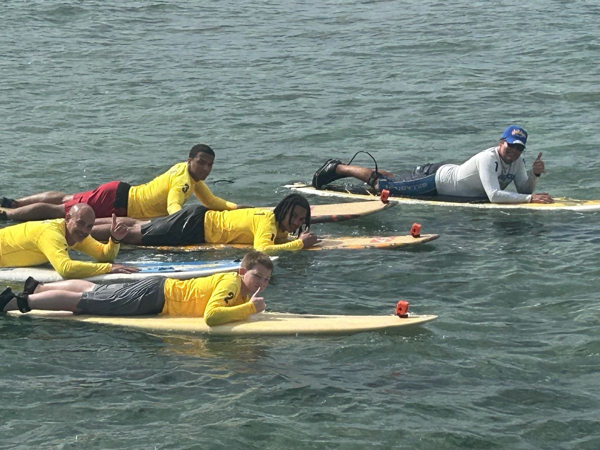 A beginner practicing prone paddle form during an SFC Waikiki lesson