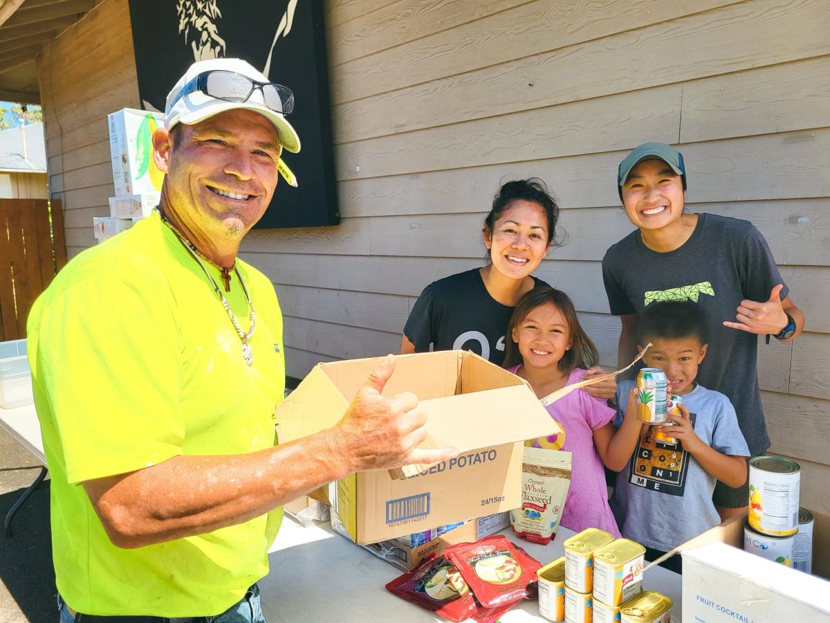 Scott and an SFC family holding community supplies together
