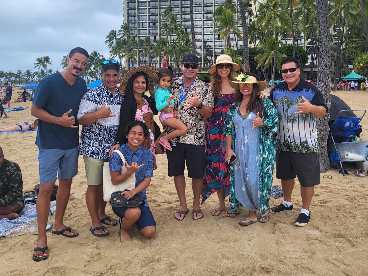 A family group gathered for a beach event in Waikiki