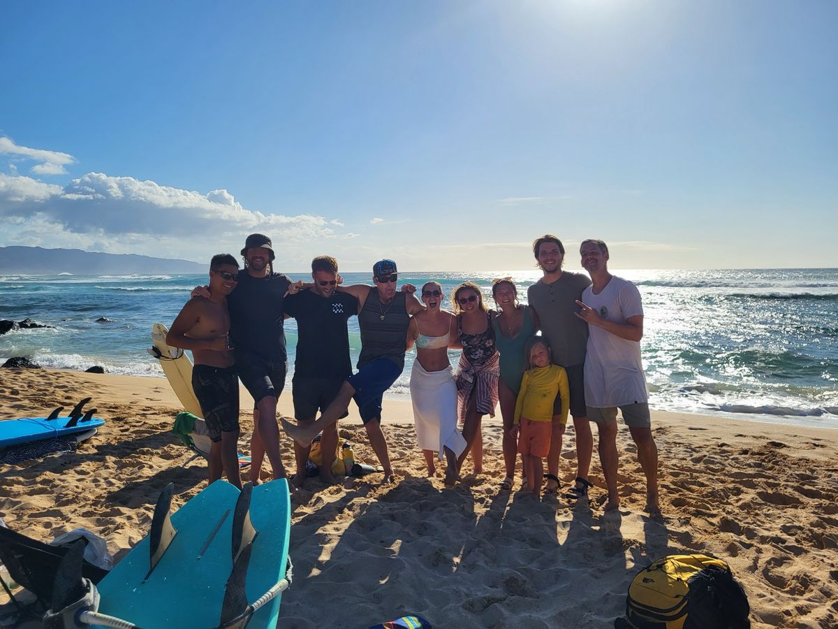 A lesson group lined up on the beach in golden-hour light