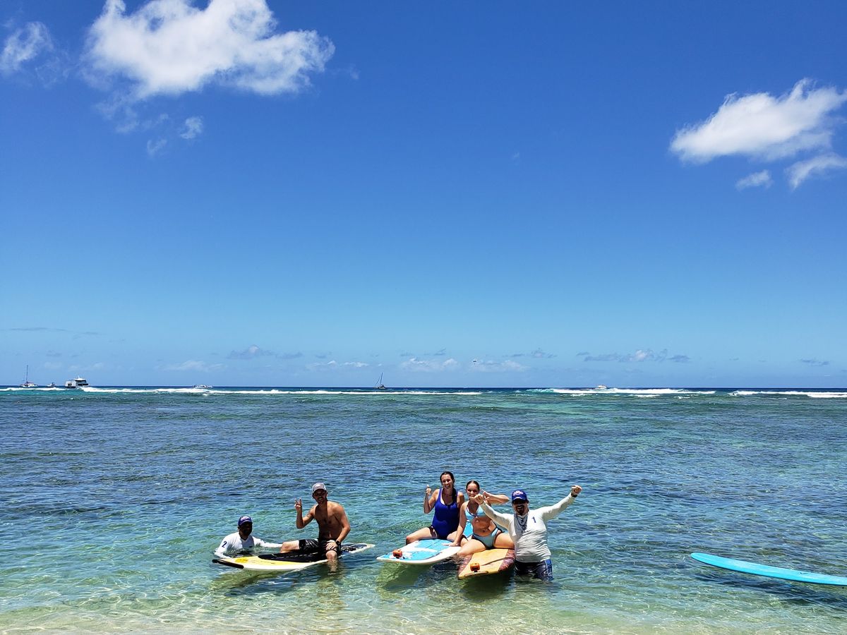 A private group throwing shakas from their boards in the Waikiki water