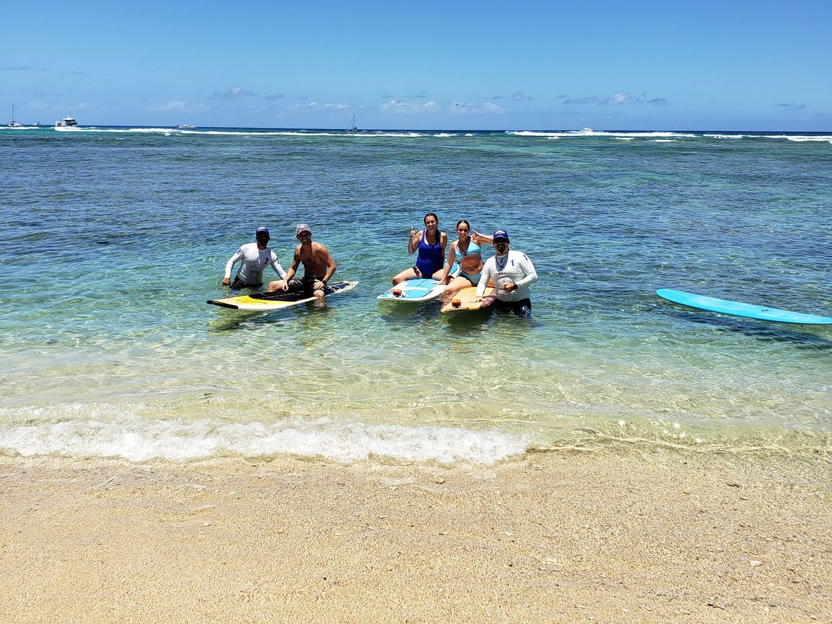 An SFC instructor coaching students on boards in the Waikiki water