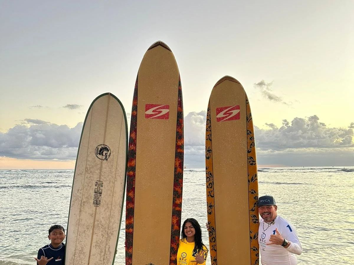 Two longboards standing against the early Waikīkī sky