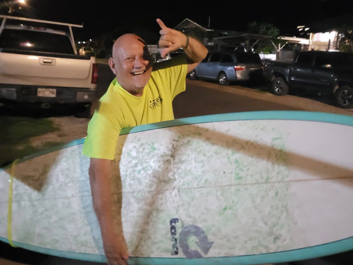 Scott Uncle Savage Minkler smiling from a longboard in the Waikīkī water