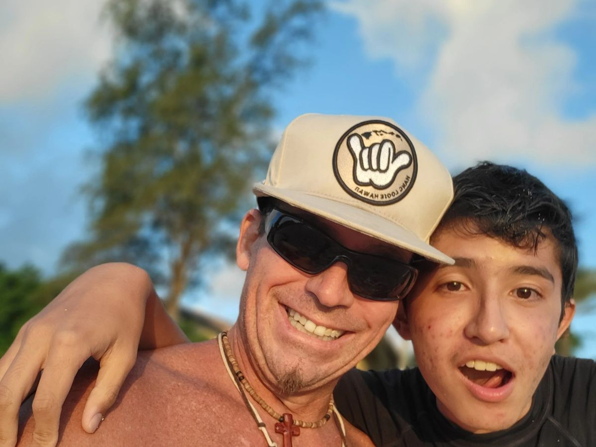 Scott Uncle Savage Minkler smiling beside a young surfer