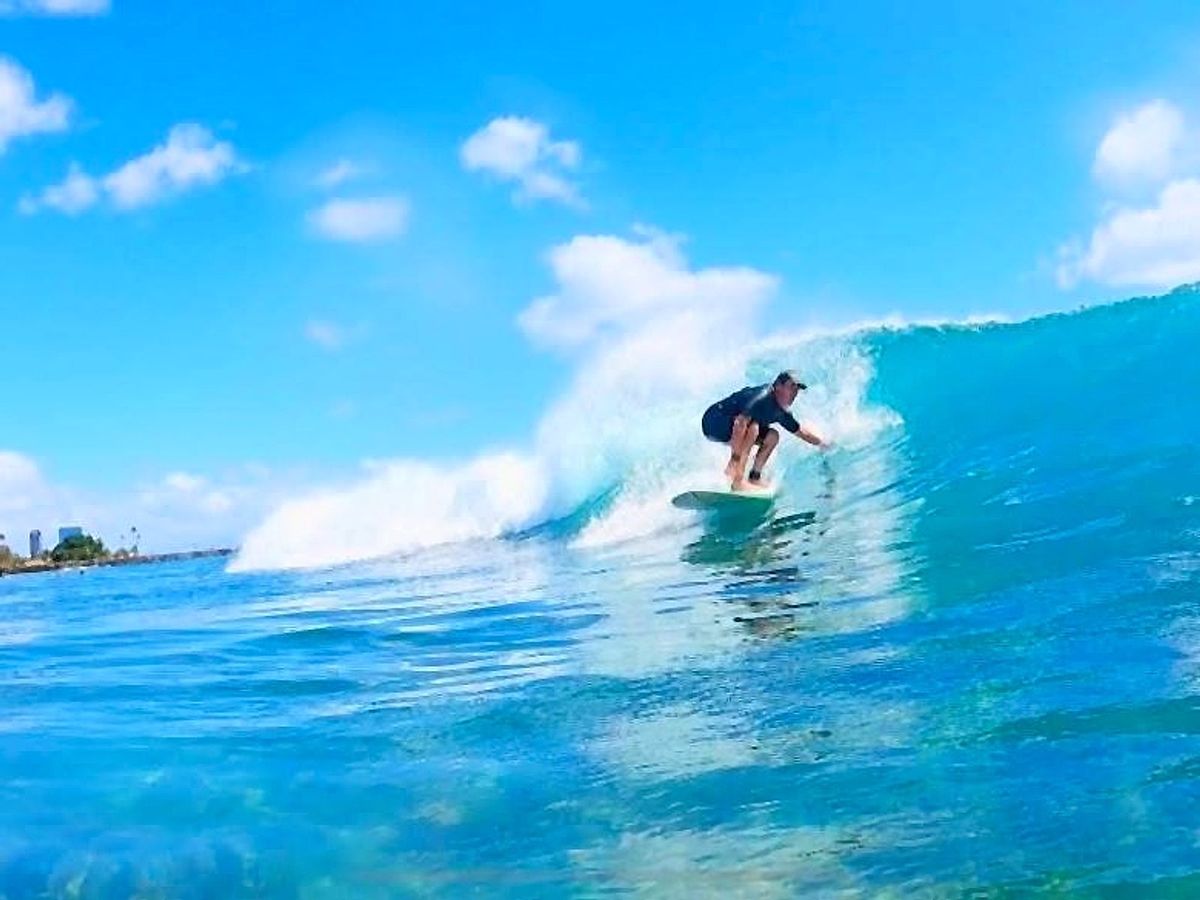 Scott "Uncle Savage" Minkler riding a clean Waikīkī wave toward the harbor channel